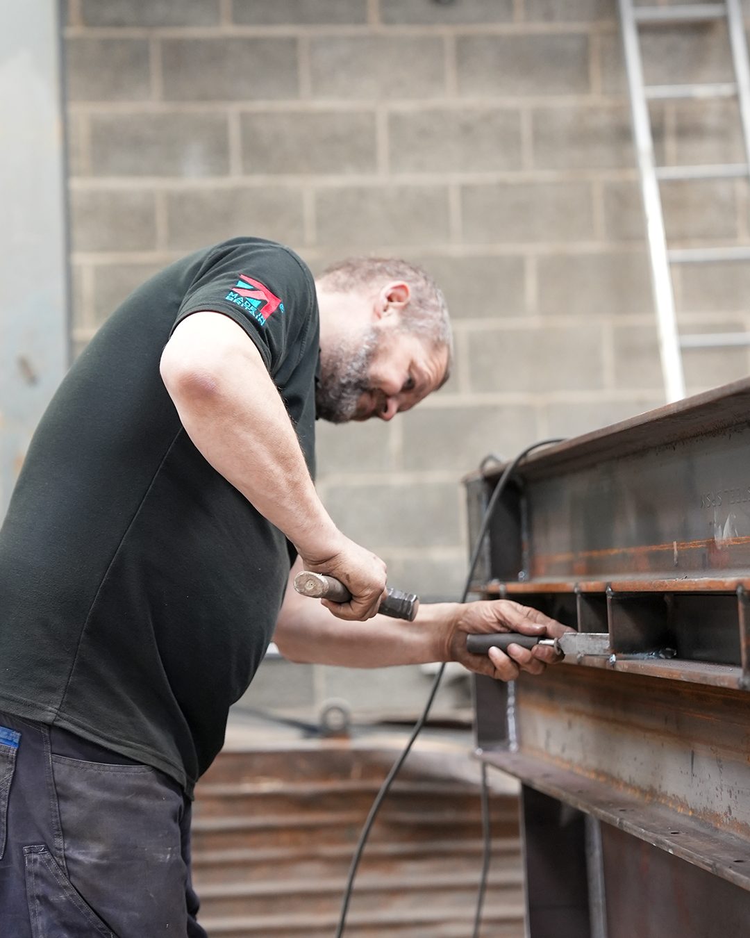 Fitter dressing a welded stiffener on a universal beam